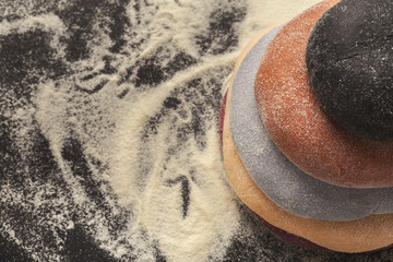 Colorful fresh pasta dough on black table