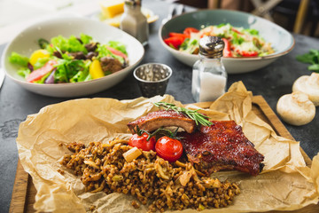 Barbecue ribs with buckwheat, salads with citrus and grilled liver, Caesar salad with tomato.