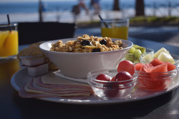 Healthy morning breakfast with fruit and muesli in a cafe with a sea view