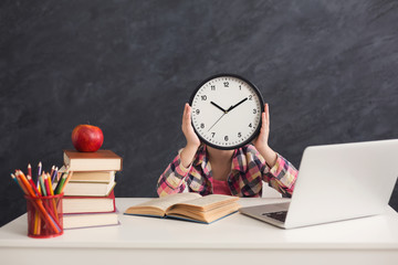Cute smart girl holding clock covering fave