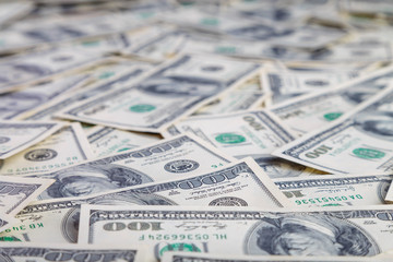 Paper 100 dollar bills spread out on the plane in a chaotic manner