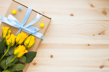 Bouquet of yellow roses, envelope and gifts. Congratulation, holiday, lifestyle concept. Space for a text. Top view. Close up.