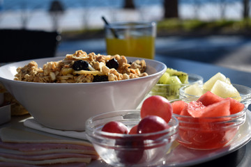 Healthy morning breakfast with fruit and muesli in a cafe with a sea view