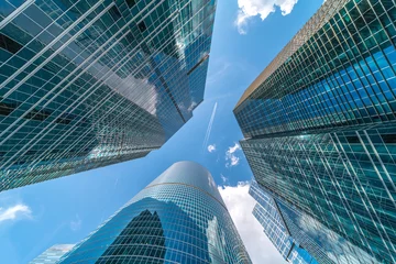 Photo sur Plexiglas construction de la ville Prise de vue en angle bas des bâtiments modernes de la ville de verre pendant la journée ensoleillée. Effet de lentille large.