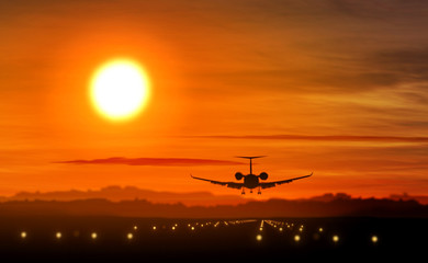 Fototapeta na wymiar Airplane landing - private jet silhouette on sunset