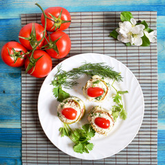Appetizer on a white plate tomatoes  on a blue background
