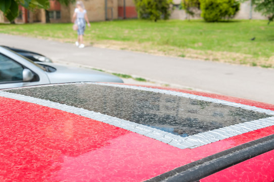 Damaged Glass Roof Window Or Sunroof On The Red Car Glued With Duct Tape To Prevent Water To Come In The Interior Of The Vehicle