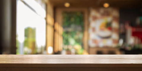 Empty wooden table top with blur coffee shop or restaurant interior background, Panoramic banner.