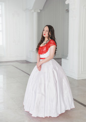 Beautiful woman in medieval dress with crinoline in the hall
