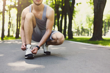 Unrecognizable man tying shoelaces before running