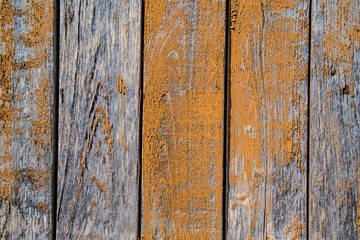 Texture of old wooden wall with peeling yellow paint.