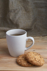 Oatmeal cookies with sunflower seeds near cup of tea.