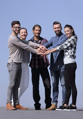 group of young people clasped their hands together