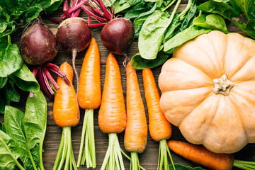 carrots, beets, spinach, pumpkin on a wooden background, fresh vegetables