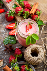 Strawberry smoothies in glass with many strawberries on wooden background. Top view. Copy space