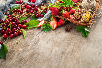 Fresh sweet cherries and strawberries on wooden background. Top view. Copy space. Flatlay