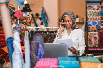 Smiling mature woman at work in her fabric shop