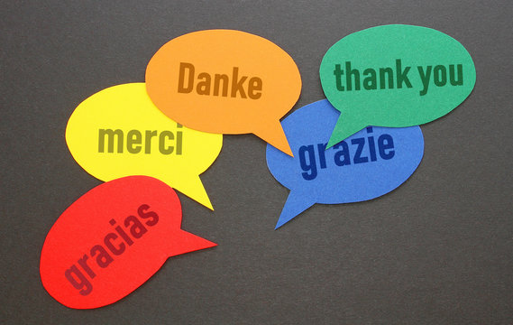 "Danke" in den wichtigsten Sprachen Europas in Sprechblasen auf dem Tisch