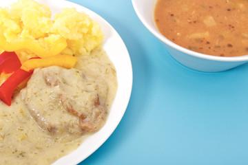 Seitan with dill sauce and potatoes on a blue