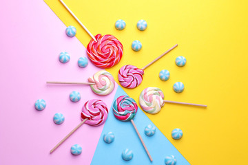 Multicolored round candy and colored lollipops on colored bright backgrounds. Top view