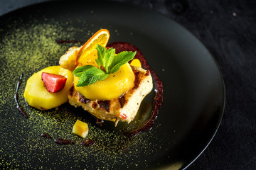 Dish with meat and caramelized pear on black background