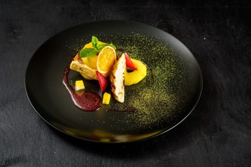 Dish with meat and caramelized pear on black