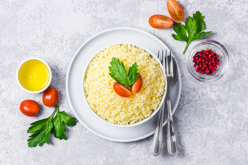 Couscous in a bowl on concrete background. Top view, space for text.