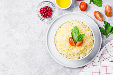 Couscous in a bowl on concrete background. Top view, space for text.