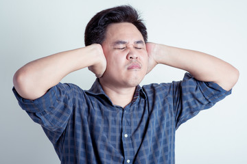 man closes his ears with hands