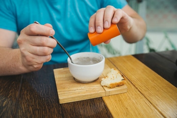 man eating soup in cafe. hold bread in other hand
