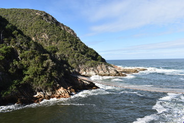 Fototapeta na wymiar Mountainous Landscape with the beautiful beach and the famous Storms River Bridge at Tsitsikamma National Park in South Africa