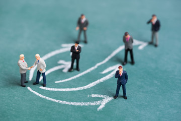business miniature people shaking hand with arrow line link connection relation to another people