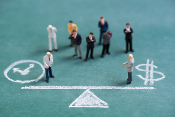 business miniature people on chalk balance time and money bar background