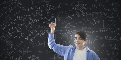 student with slate background with formulas