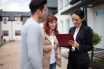 Real estate agent offer ownership contract for new house to young couple