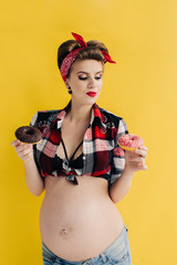 pregnant girl in pin-up style with two donut in hand