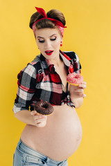 pregnant girl in pin-up style with two donut in hand