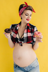 pregnant girl in pin-up style with two donut in hand