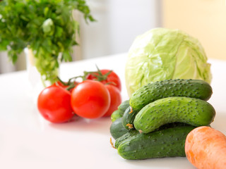 Fresh seasonal vegetables for salad or other vegetable dishes. Cabbage, tomato, cucumber, onions - healthy food.