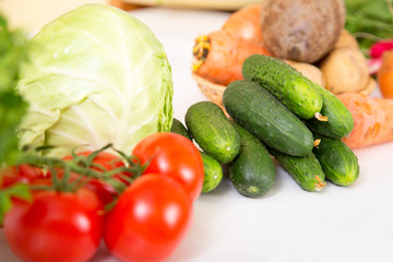 Fresh seasonal vegetables for salad or other vegetable dishes. Cabbage, tomato, cucumber, onions - healthy food.