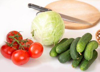 Fresh seasonal vegetables for salad or other vegetable dishes. Cabbage, tomato, cucumber, onions - healthy food.