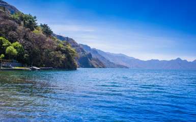 Beautiful outdoor view of shore at Lake Atitlan, during a gorgeous sunny day and blue water in Guatemala