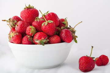  Strawberries in a white bowl on a white background. Copy space. 