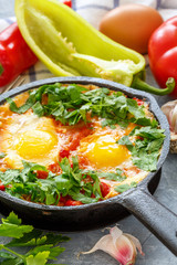 Shakshuka. Frying pan with eggs in tomato sauce.