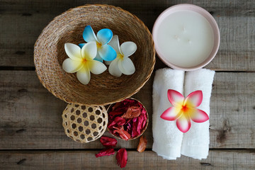 White towels decorate with orange flower near dry aroma rose on spa set table.
