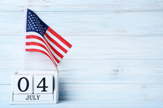 American flag with cube calendar on wooden table
