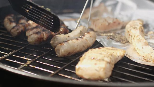 Sausages and salmon being cooked on a barbecue grill, in slow motion