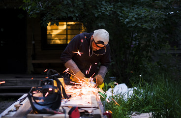 Man welding outside the house on a summer day