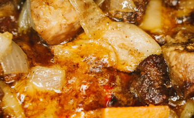 Roast meat, onions, carrots and spices, boiling in oil
