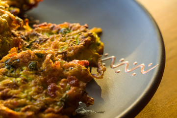 Fried vegetable fritters with zucchini, carrots, herbs, eggs, and cheese.